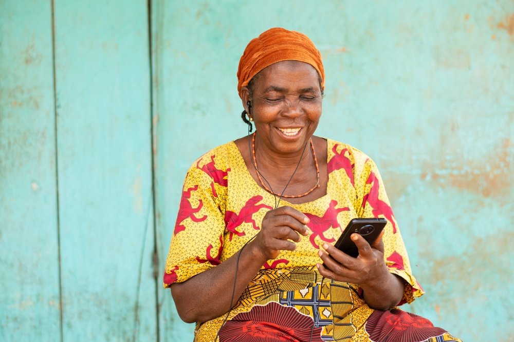 Happy,Old,African,Woman,Using,Her,Phone,,Listening,To,Music