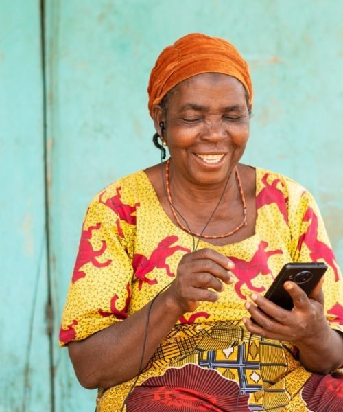 Happy,Old,African,Woman,Using,Her,Phone,,Listening,To,Music